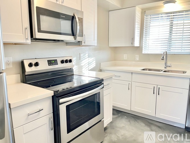 A kitchen with white cabinets and appliances.