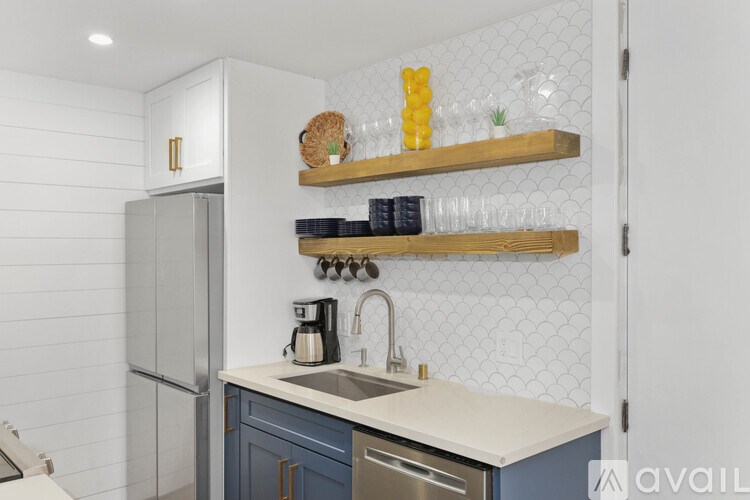 A kitchen with a white refrigerator, a sink, and a countertop with a coffee maker.