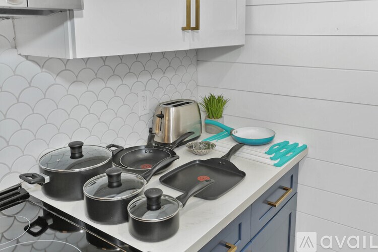 A kitchen counter with a toaster, pots, and pans.