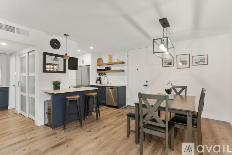 A kitchen with a bar and dining table.