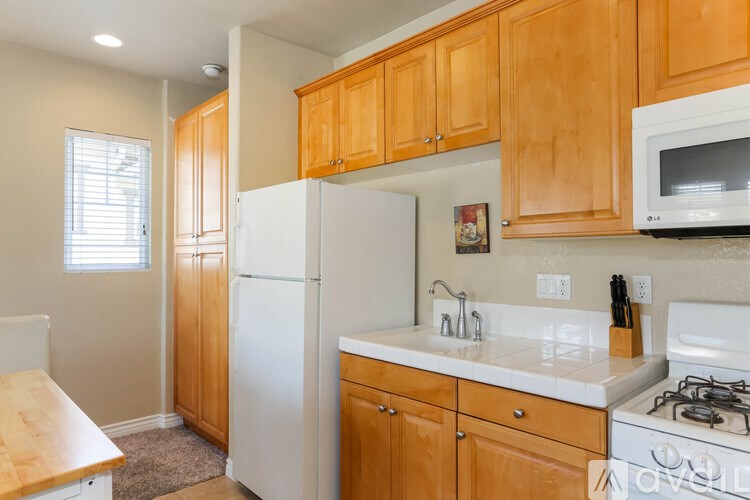 A kitchen with wooden cabinets and white appliances.
