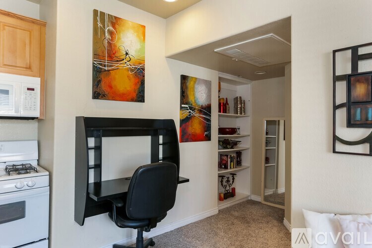 A kitchen with a black chair and a painting on the wall.