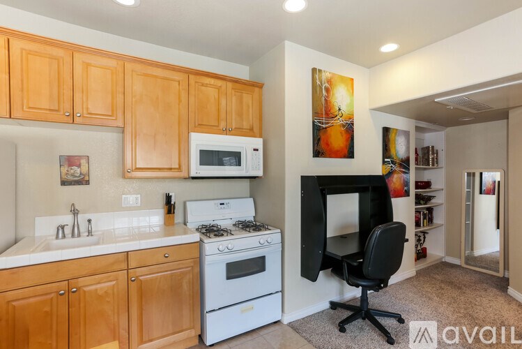 A kitchen with wooden cabinets and a white stove top oven.