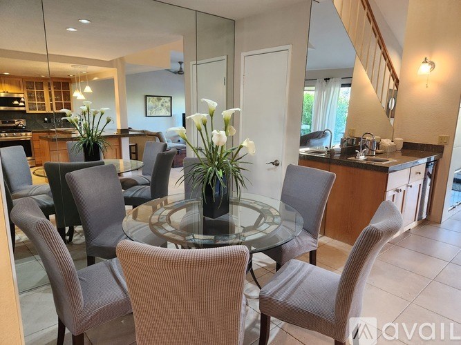 A modern dining room with a glass table and chairs.