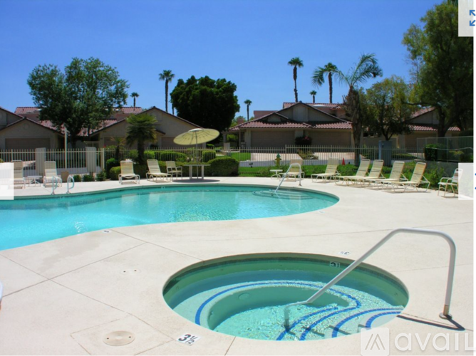 A pool with a slide and a hot tub in the middle.