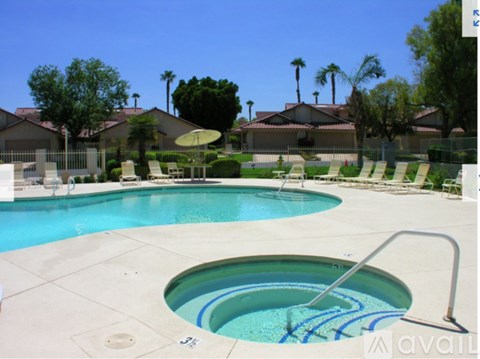A pool with a slide and a hot tub in the middle.