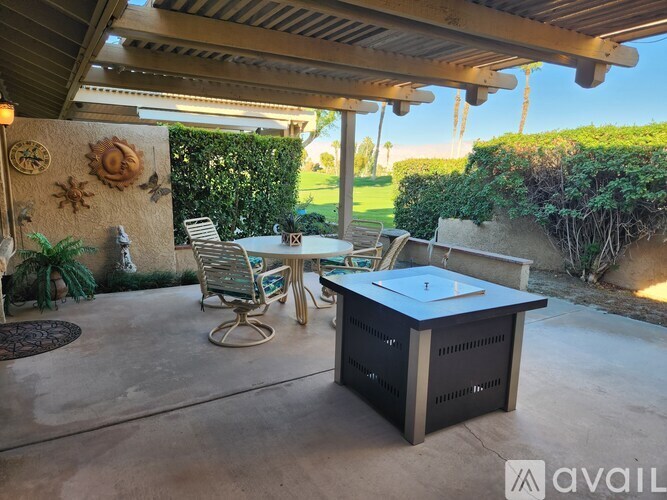 A patio with a table and chairs under a roof.