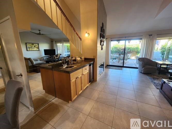 A spacious living room with a kitchen area and a television.