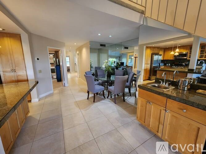 A kitchen with a dining table and chairs in the middle of the room.