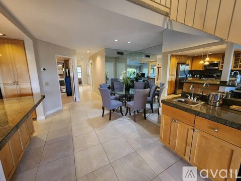 A kitchen with a dining table and chairs in the middle of the room.
