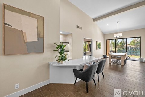 A modern dining room with a white table and chairs.