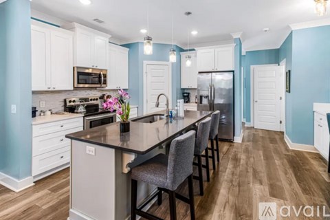 A kitchen with a long island and chairs.