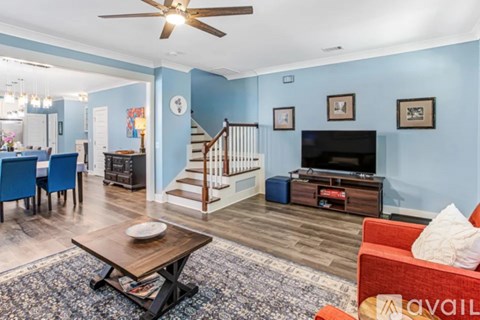 A living room with a blue wall and a wooden coffee table.