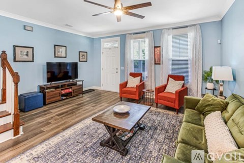 A living room with a wooden floor and furniture.
