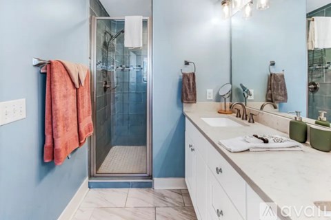 A bathroom with a blue wall and a white counter.