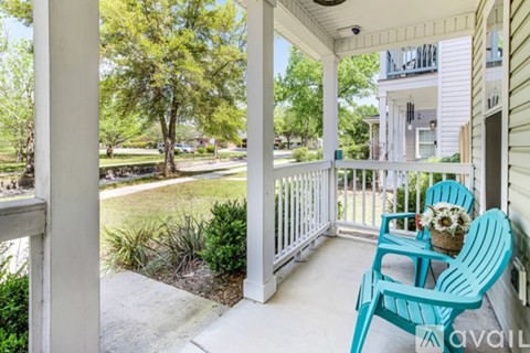 A white house with a blue chair on the porch.