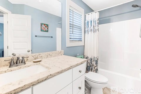 A bathroom with a sink, toilet, and bathtub.