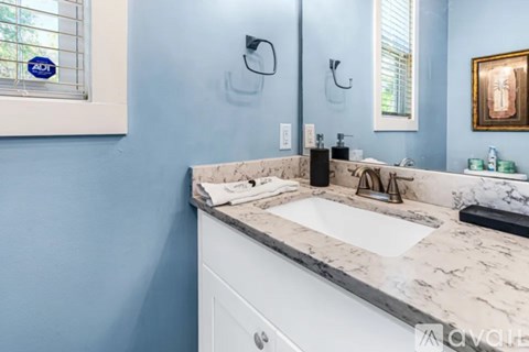 A bathroom with a marble countertop and a white sink.