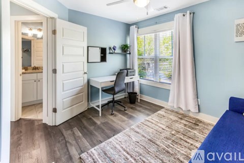 A room with a desk and a bed.