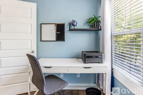 A white desk with a grey chair and a printer on it.