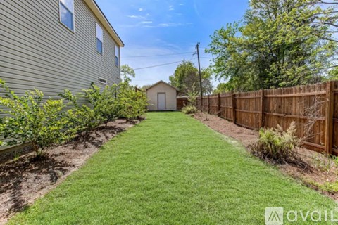 A backyard with a wooden fence and a green lawn.