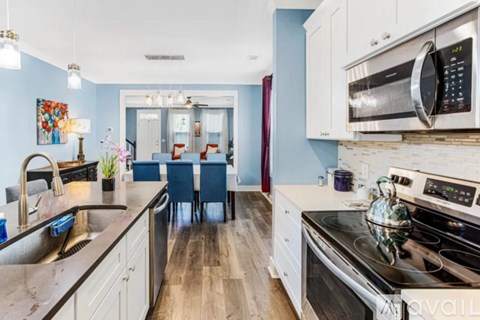 A kitchen with a black countertop and a stainless steel oven.