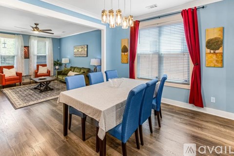 A dining room with a table set for six and a fan on the ceiling.