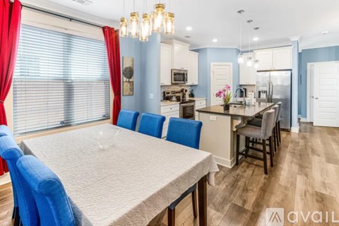 A dining room with a table and chairs.