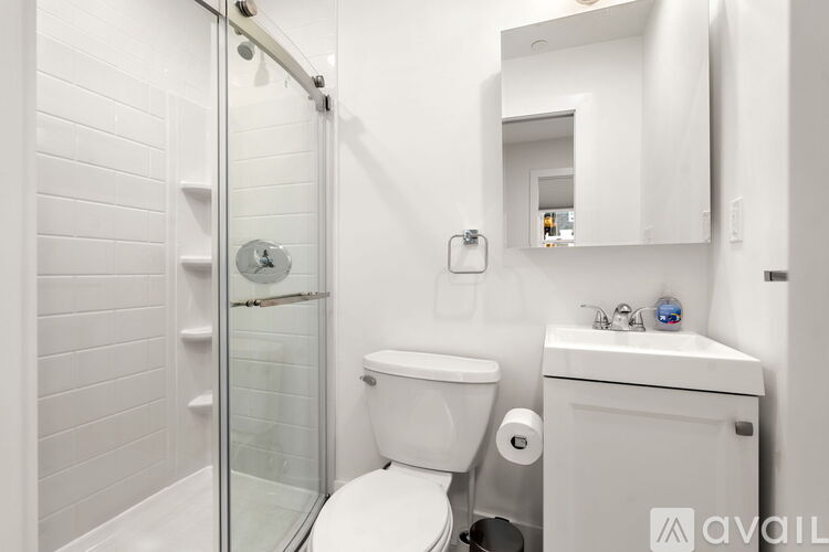 A white toilet sits next to a sink in a small bathroom.