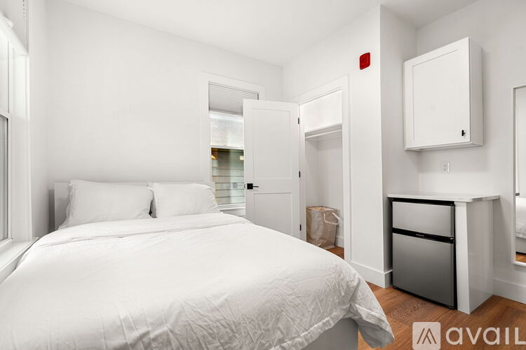 A bedroom with a large bed and a small kitchenette.