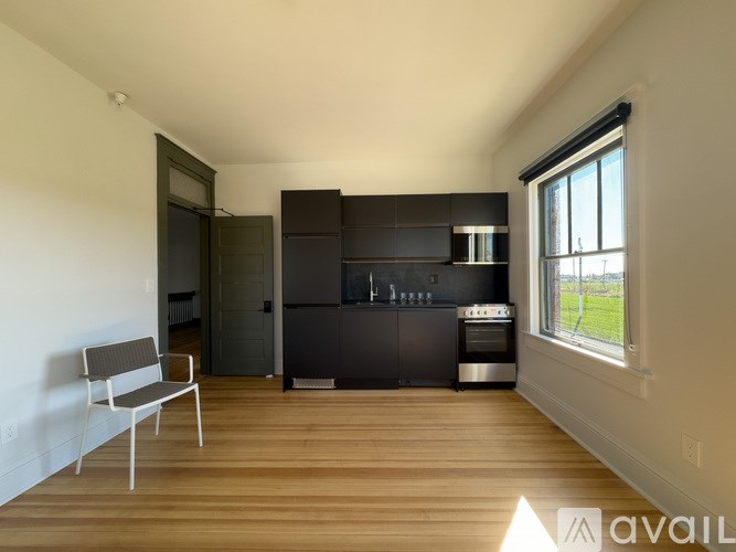 A modern kitchen with a wooden floor and a window.