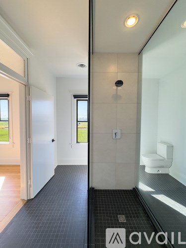 A bathroom with a toilet, sink and mirror.