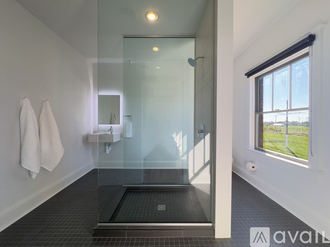 A bathroom with a glass shower door and a walk-in shower.