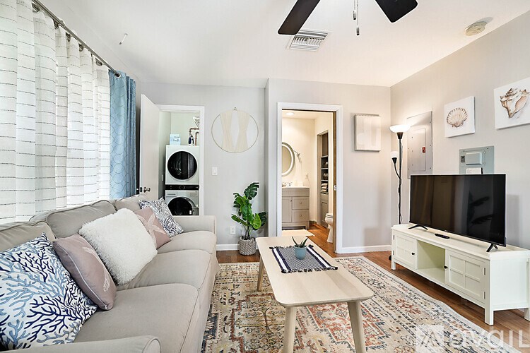 A living room with a couch, a coffee table, and a television.