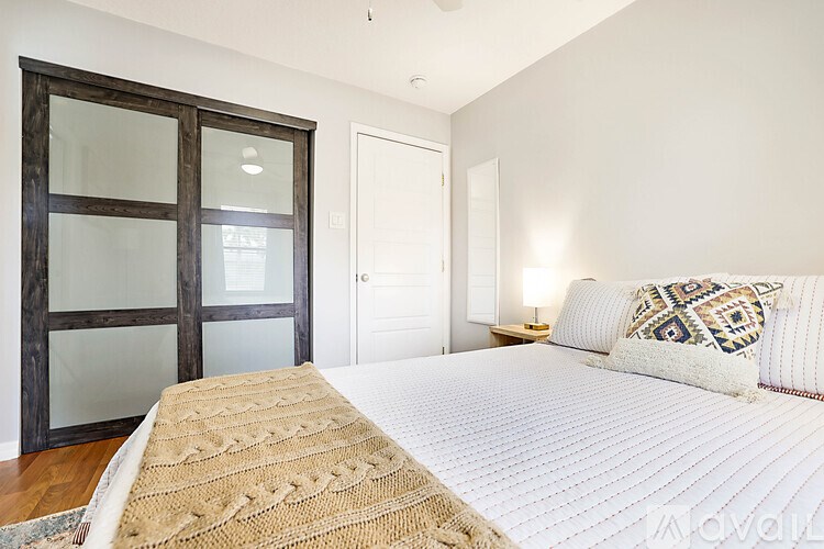 A bedroom with a large bed and a glass door.