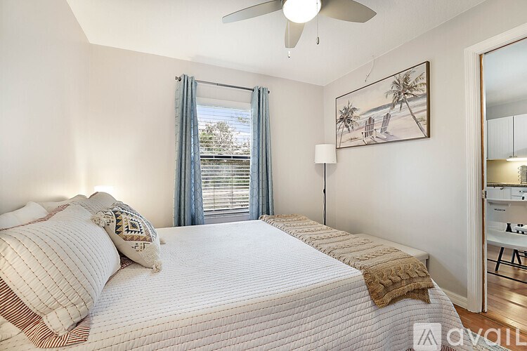 A bedroom with a large bed and a ceiling fan.