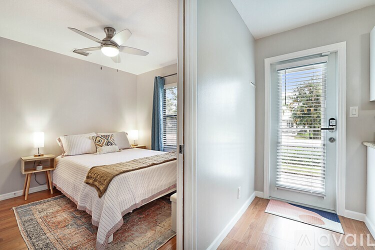 A bedroom with a bed, a ceiling fan, and a window with blinds.