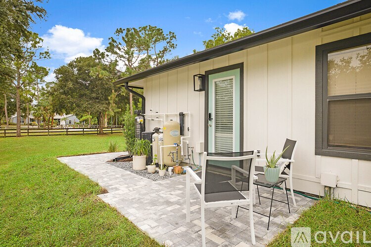 A patio with chairs and a table outside a house.