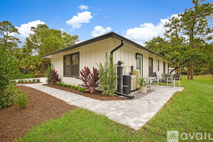 A house with a flag on the window and a white fence around it.