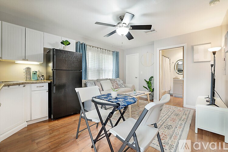 A kitchen with a black refrigerator and white cabinets.