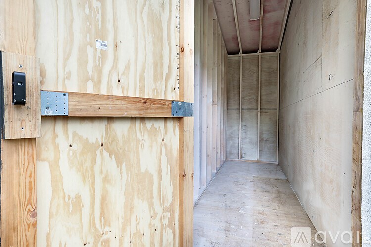 A room under construction with wooden walls and a door.