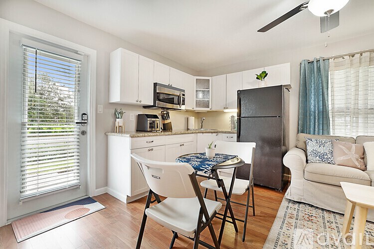 A kitchen with a table and chairs in front of a refrigerator.
