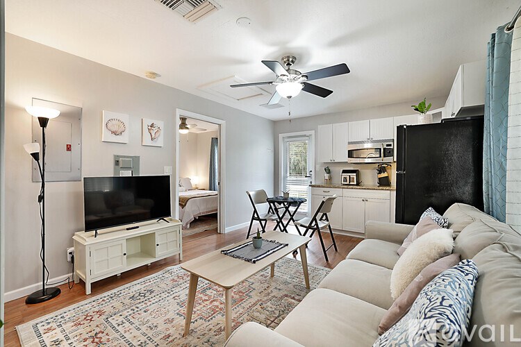 A living room with a white couch and a television.