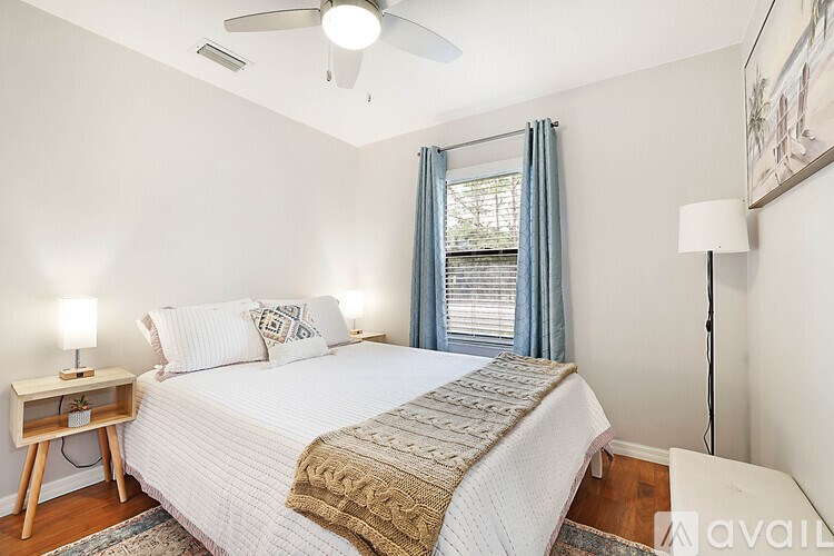 A bedroom with a large bed and a ceiling fan.