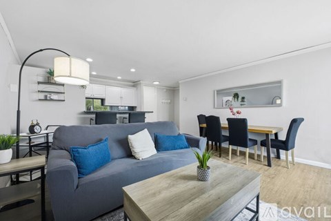 A kitchen with white cabinets and a black bar stool.