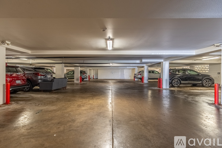 A spacious garage with a concrete floor and a few cars parked inside.