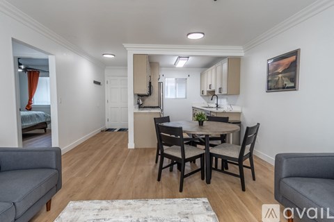 A dining room with a table set for four and a couch.