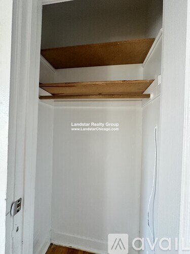 A white closet with a wooden shelf above it.