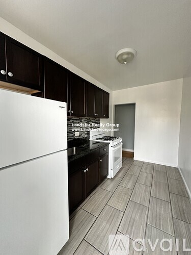 A kitchen with a white fridge and black cabinets.