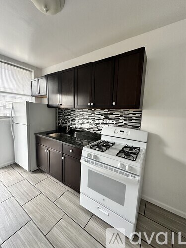 A kitchen with a white stove top oven and a white dishwasher.